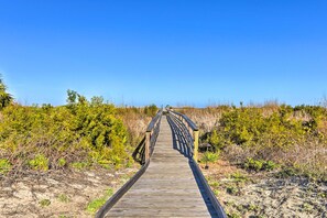 Un paseo marítimo de madera que atraviesa un paisaje natural.