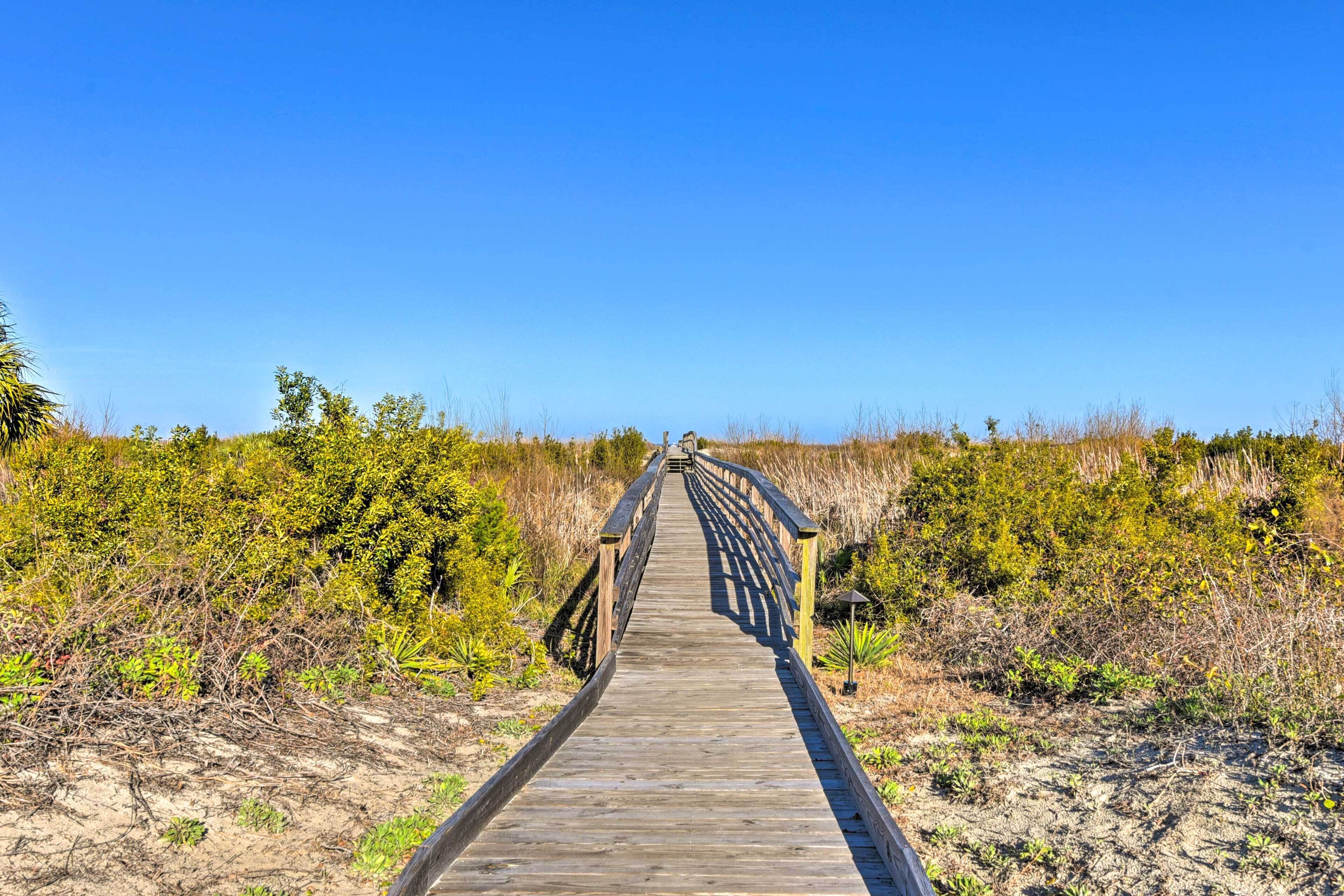 A wooden boardwalk leading through a natural landscape.