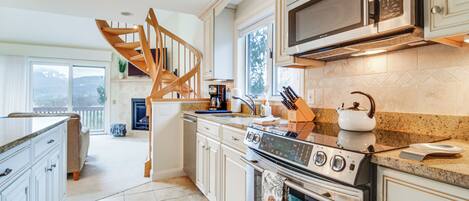 A kitchen with a built-in stove, microwave, and granite countertop.