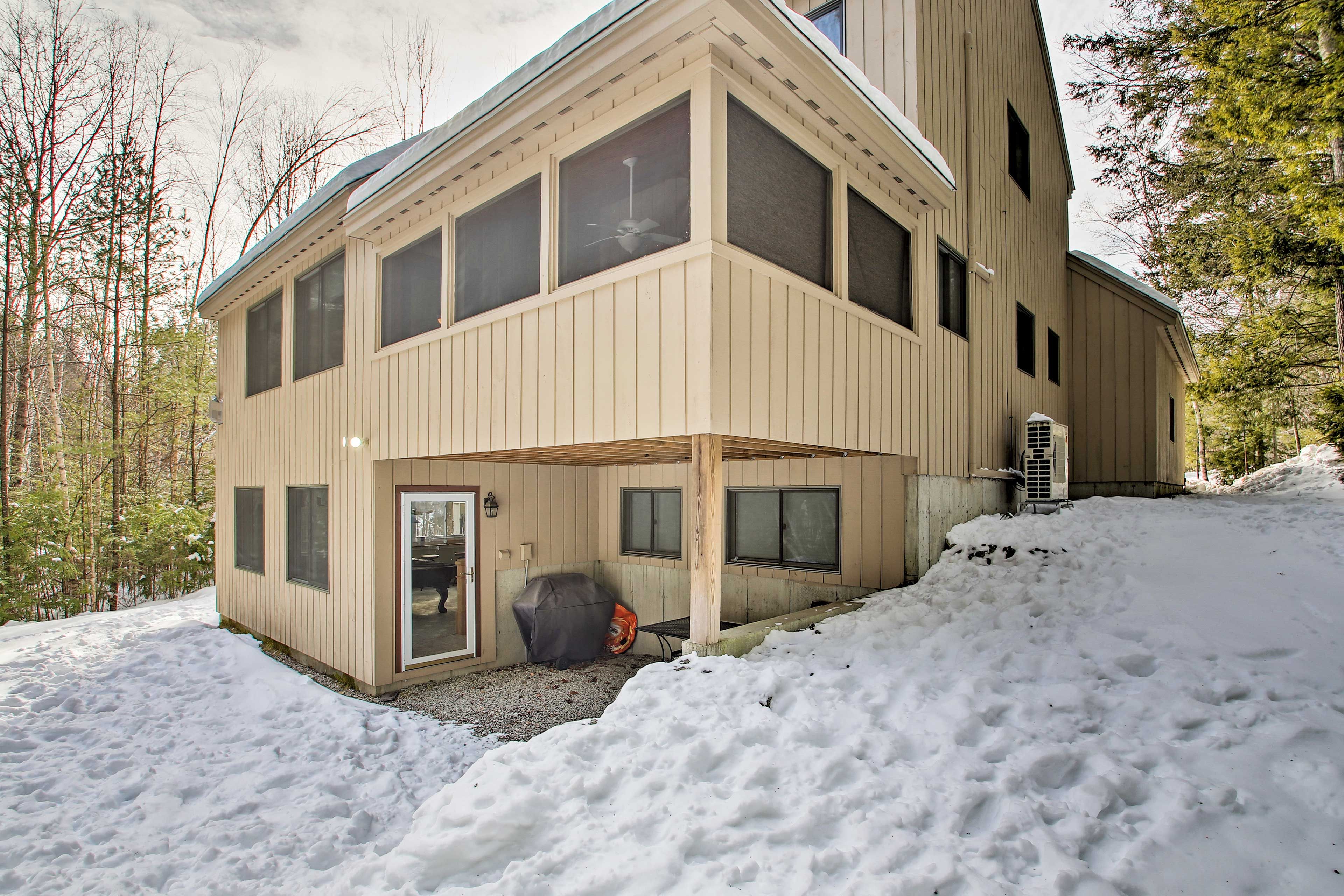 A two-story building with a covered patio area and a large window.