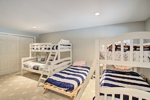 A room with bunk beds, a closet, and a door.