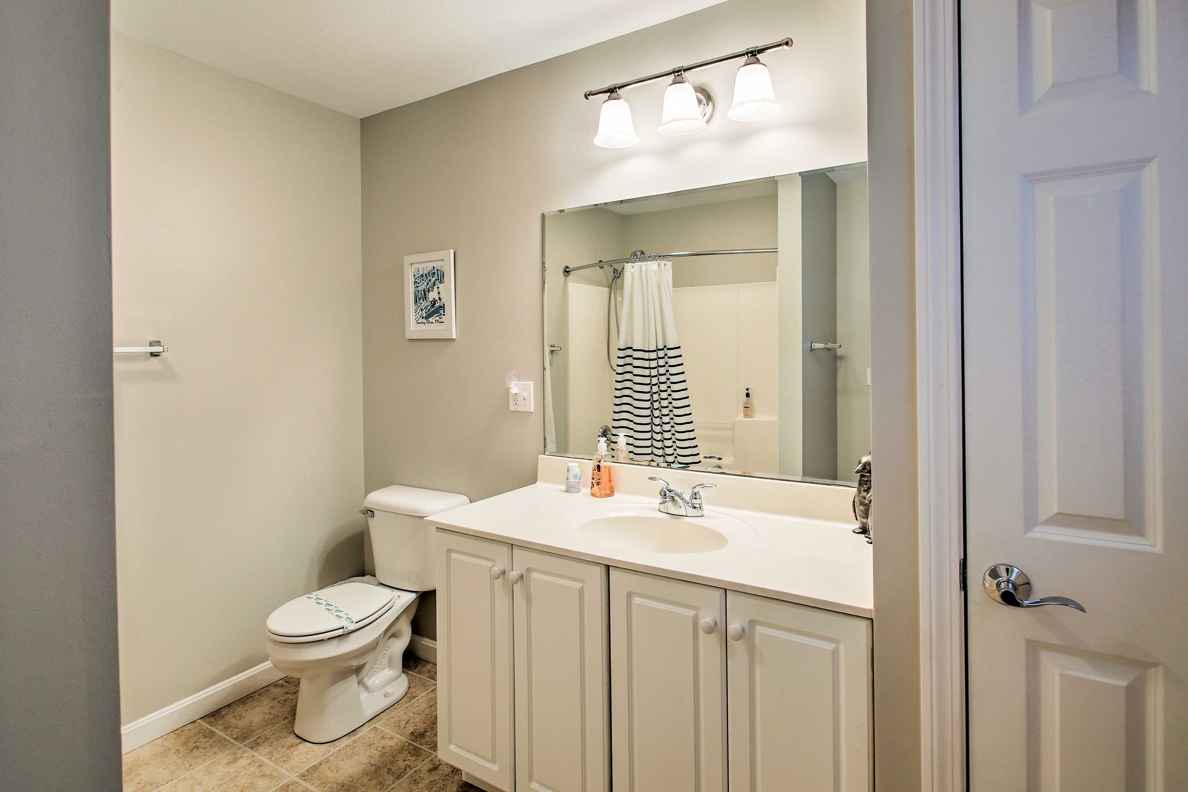Une salle de bain avec des toilettes, un lavabo et un miroir.