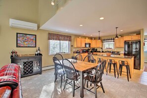 A modern kitchen with a central island, wooden cabinets, and stainless steel appliances.