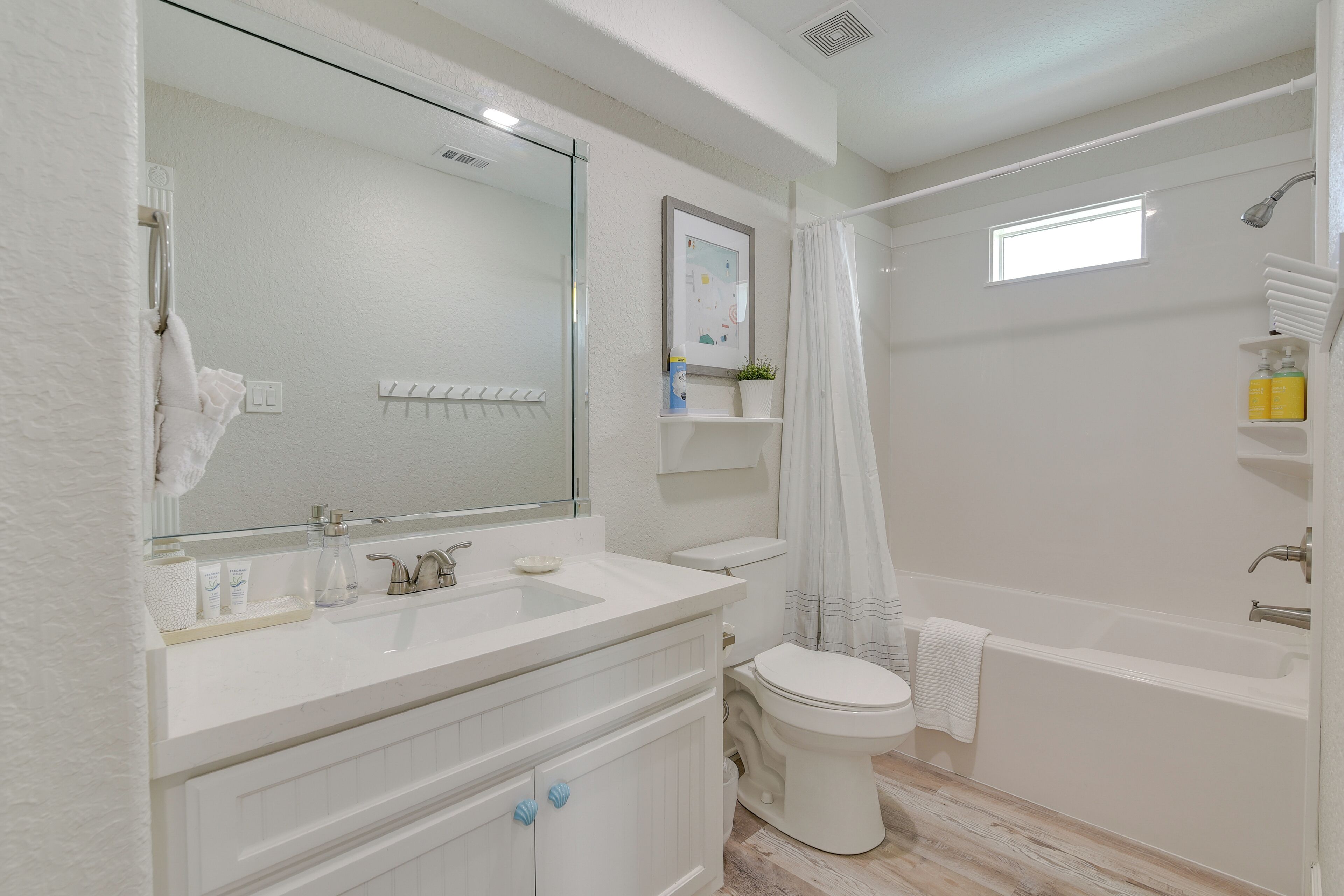 Een moderne badkamer met een wit wastafelmeubel, een toilet en een bad.