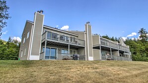 A two-story residential building with a balcony on the upper floor, a covered patio area, and a chimney on each side. - Intervale Family Retreat: Mtn View & Pool Access! (Intervale)