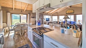Una cocina amplia con una isla grande, vigas de madera en el techo y vistas al exterior.