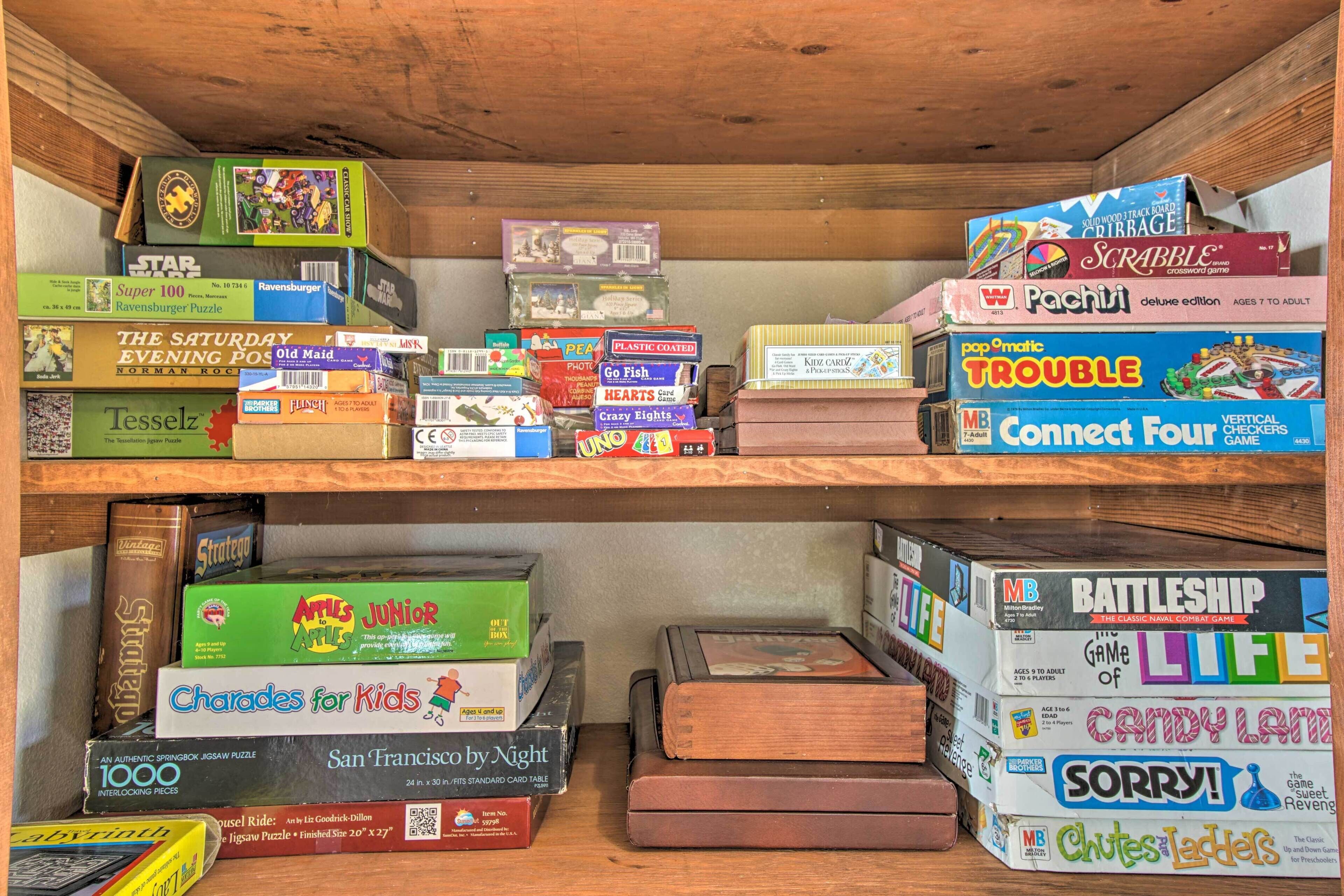 A collection of board games and puzzles on shelves.