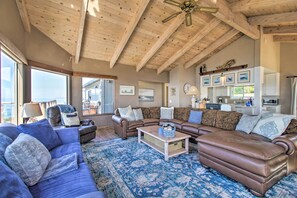 A spacious living room with a high ceiling, a large window, and a fireplace. - Spectacular Ocean View Retreat w/ Hot Tub (Manchester)