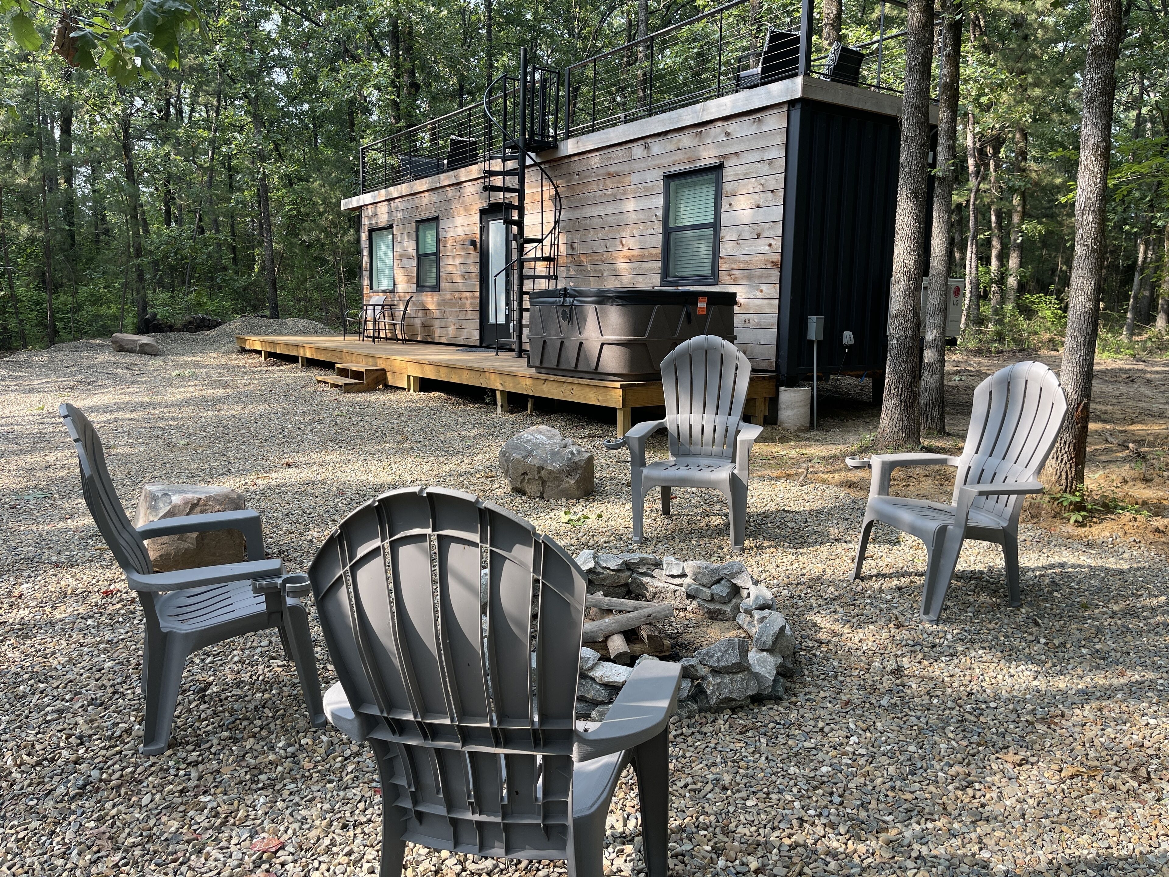 Une cabane dotée d’une terrasse, d’un espace salon extérieur et d’un foyer.