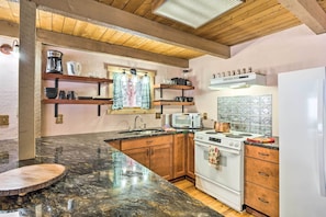 A kitchen with wooden cabinets, a granite countertop, a white stove, and a microwave. - Near Breckenridge Ski: Mtn Escape w/ Hot Tub! (Breckenridge)