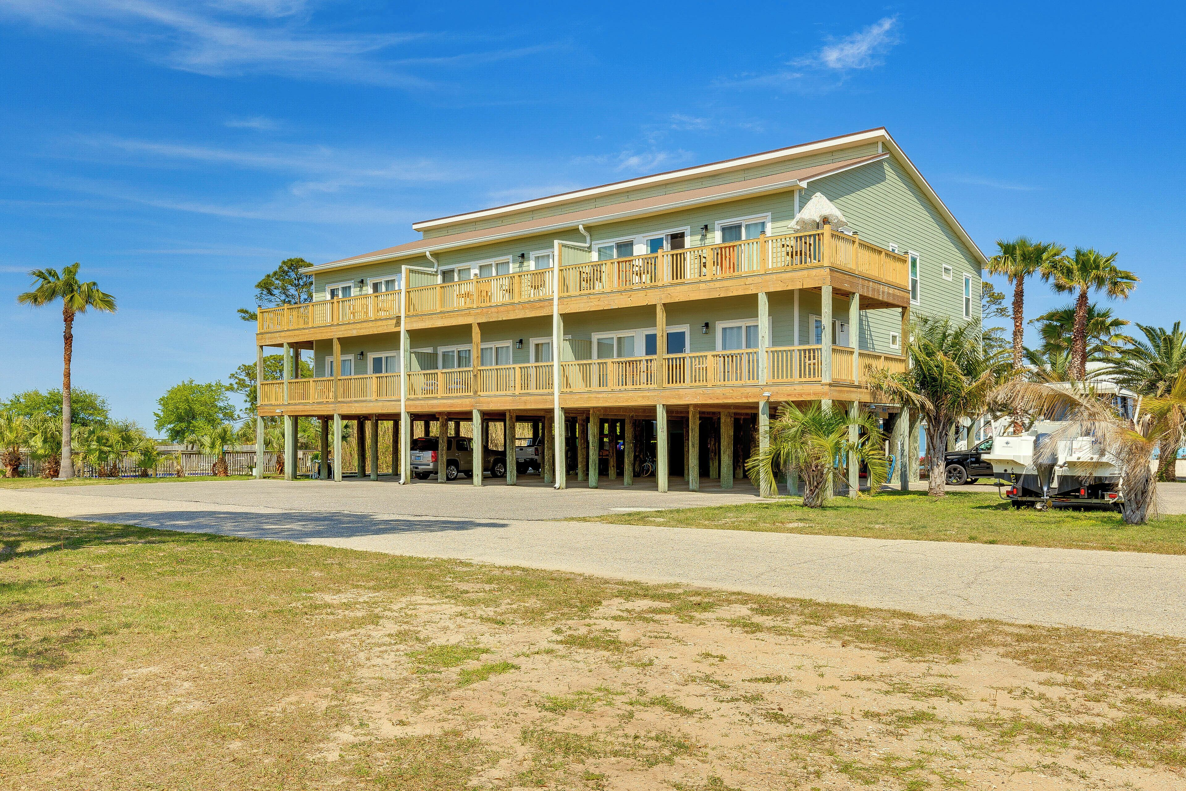 A two-story hotel with a balcony on the upper floor, a covered front porch, and a parking area in front.