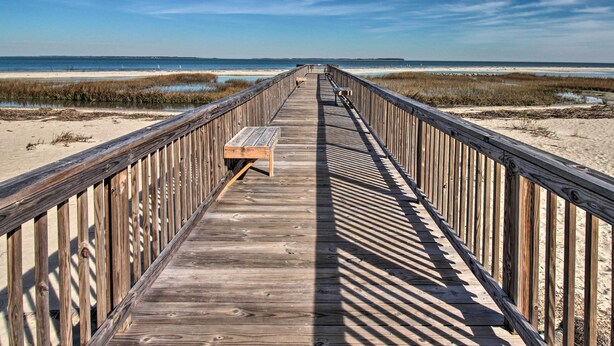 A wooden boardwalk leading to a beach with a bench and a trash can. - Family-friendly Condo w/ Pools + Tennis Courts! (Hilton Head Island)