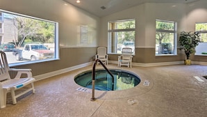 A pool area with a hot tub, chairs, and large windows offering views of the outside. - Family-friendly Condo w/ Pools + Tennis Courts! (Hilton Head Island)