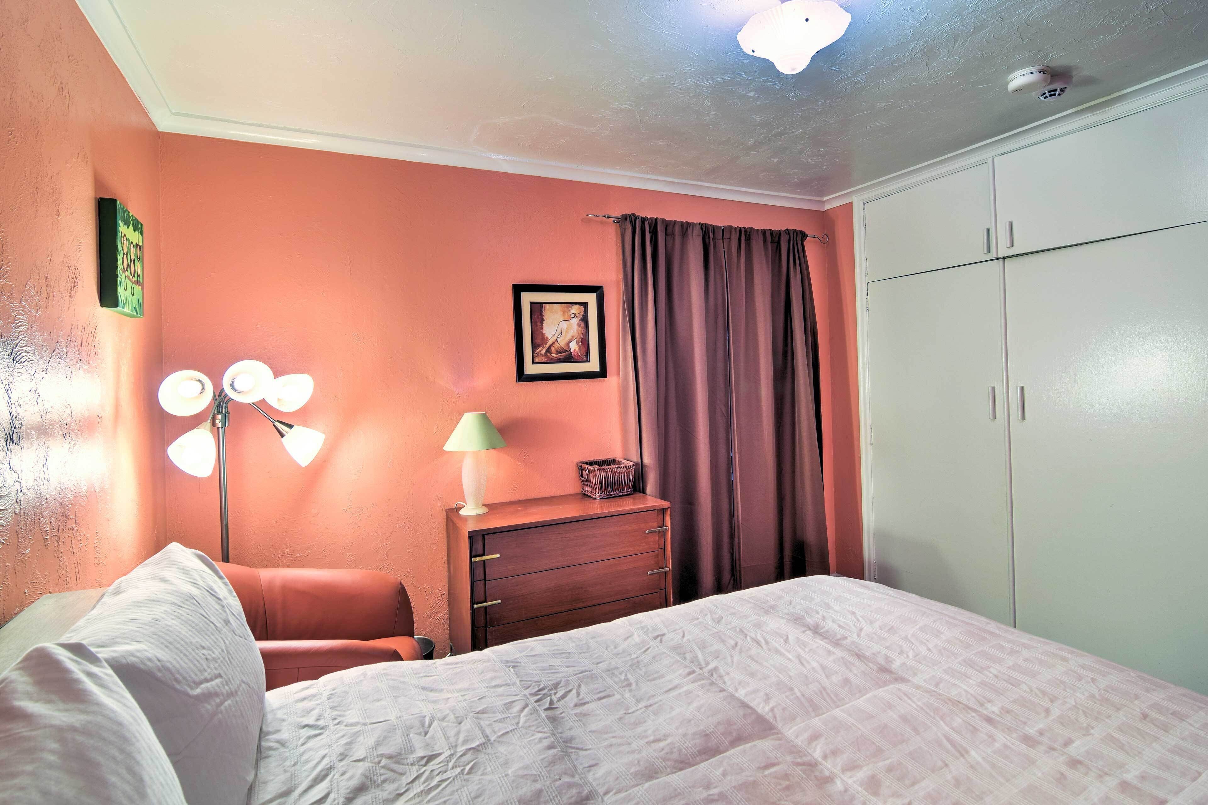 A bedroom with a bed, a dresser, a lamp, and a wardrobe.