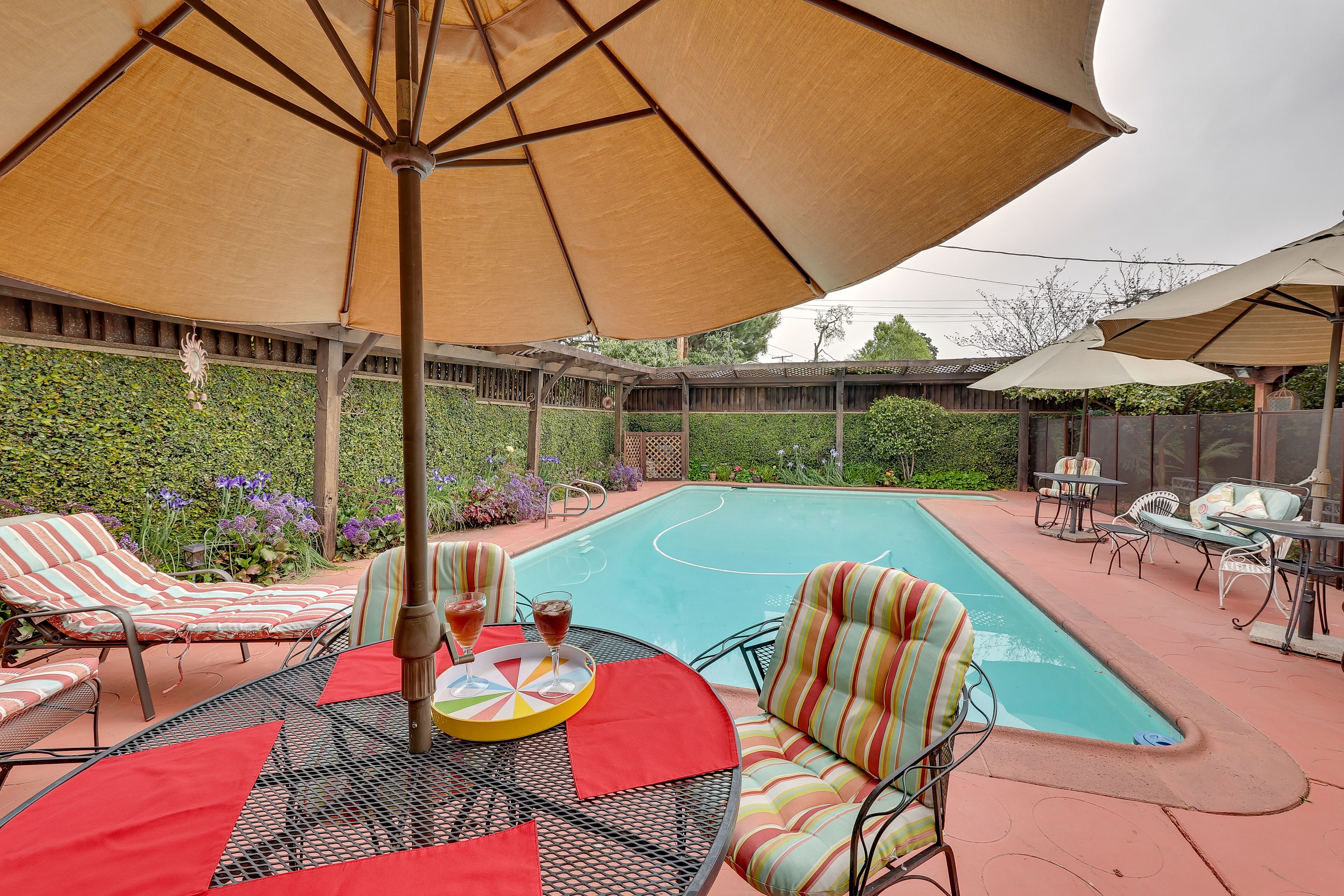 An outdoor pool area with lounge chairs and umbrellas.