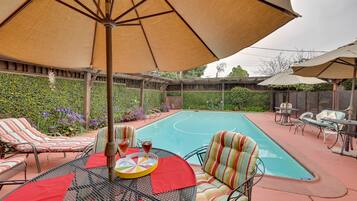 An outdoor pool area with lounge chairs and umbrellas.