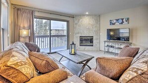 A living room with a sofa set, a fireplace, a TV, and a balcony with curtains. - 8 Mi to Copper Mtn: Sleek Frisco Townhome w/ Views (Frisco)