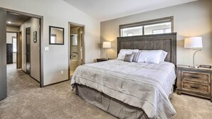 A bedroom with a large bed, two bedside tables, a nightstand, a mirror above the bed, and a door leading to another room. - 8 Mi to Copper Mtn: Sleek Frisco Townhome w/ Views (Frisco)