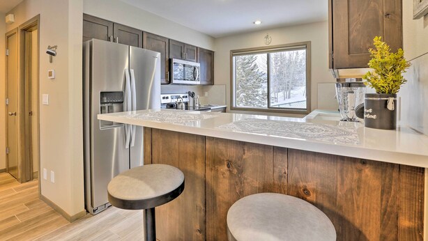 A modern kitchen with stainless steel appliances, wooden cabinets, and a large window. - 8 Mi to Copper Mtn: Sleek Frisco Townhome w/ Views (Frisco)