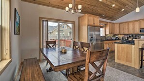 A spacious kitchen with wooden cabinets, a large island, and a dining area with a wooden table and chairs. - 9 Mi to Heavenly Mountain: South Lake Tahoe Home! (South Lake Tahoe)