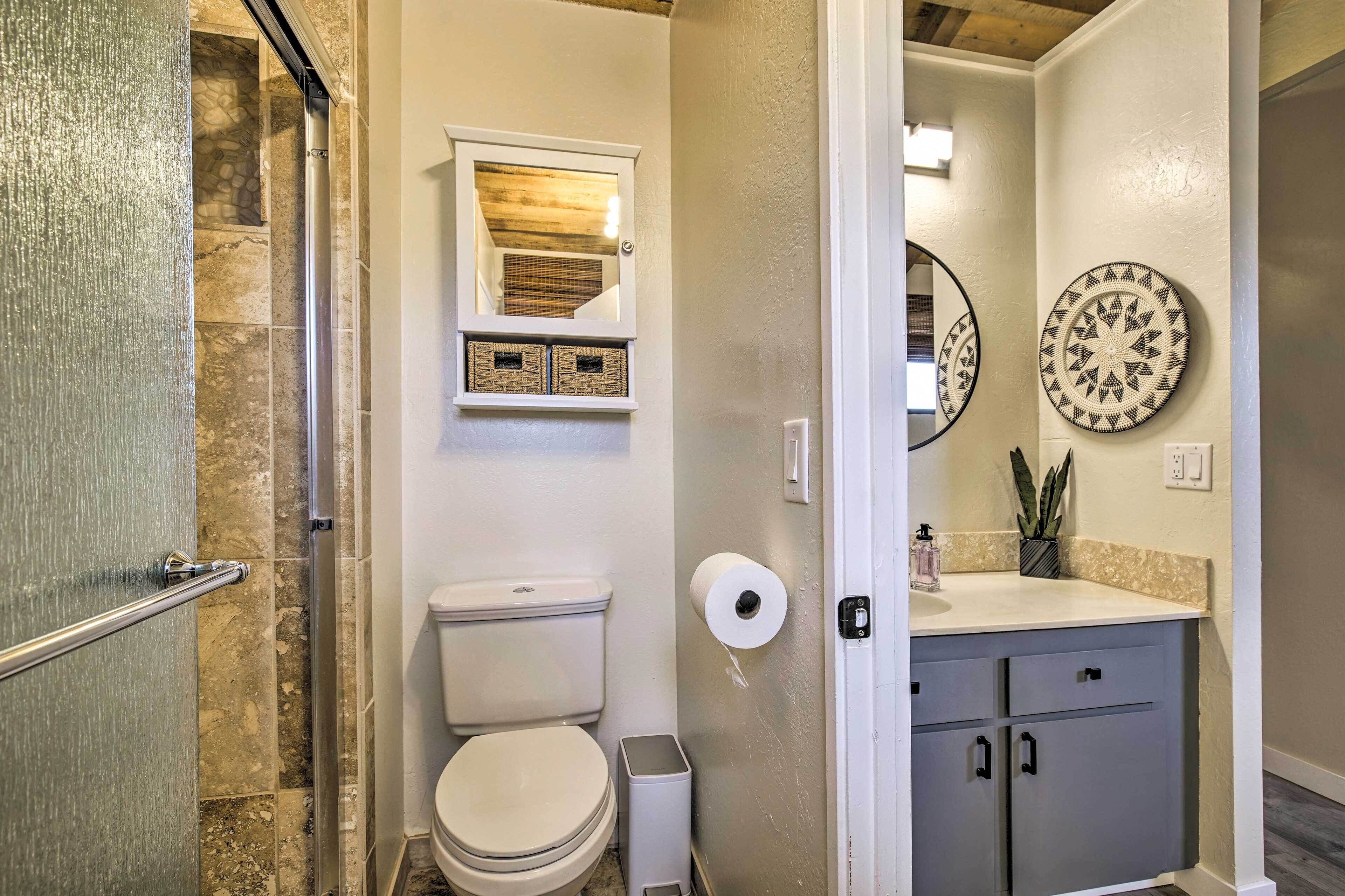 A bathroom with a shower, toilet, and sink.