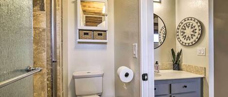 Een badkamer met een douche, toilet en wastafel.