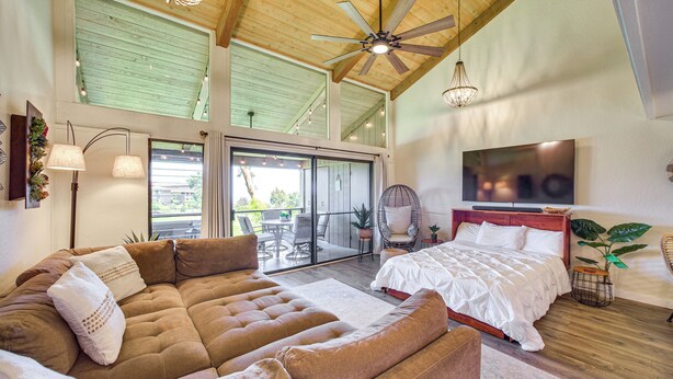 A spacious bedroom with a large bed, a sofa, and a ceiling fan. - Chic Waikoloa Condo w/ Lanai + Complex Pools! (Waikoloa)
