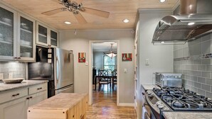 A modern kitchen with a gas stove, stainless steel appliances, and a wooden bench. - 3 Mi to Soco: City Escape w/ Patio (Austin)