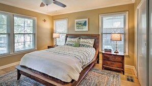 A bedroom with a bed, two bedside tables, a ceiling fan, and a window with blinds. - 3 Mi to Soco: City Escape w/ Patio (Austin)