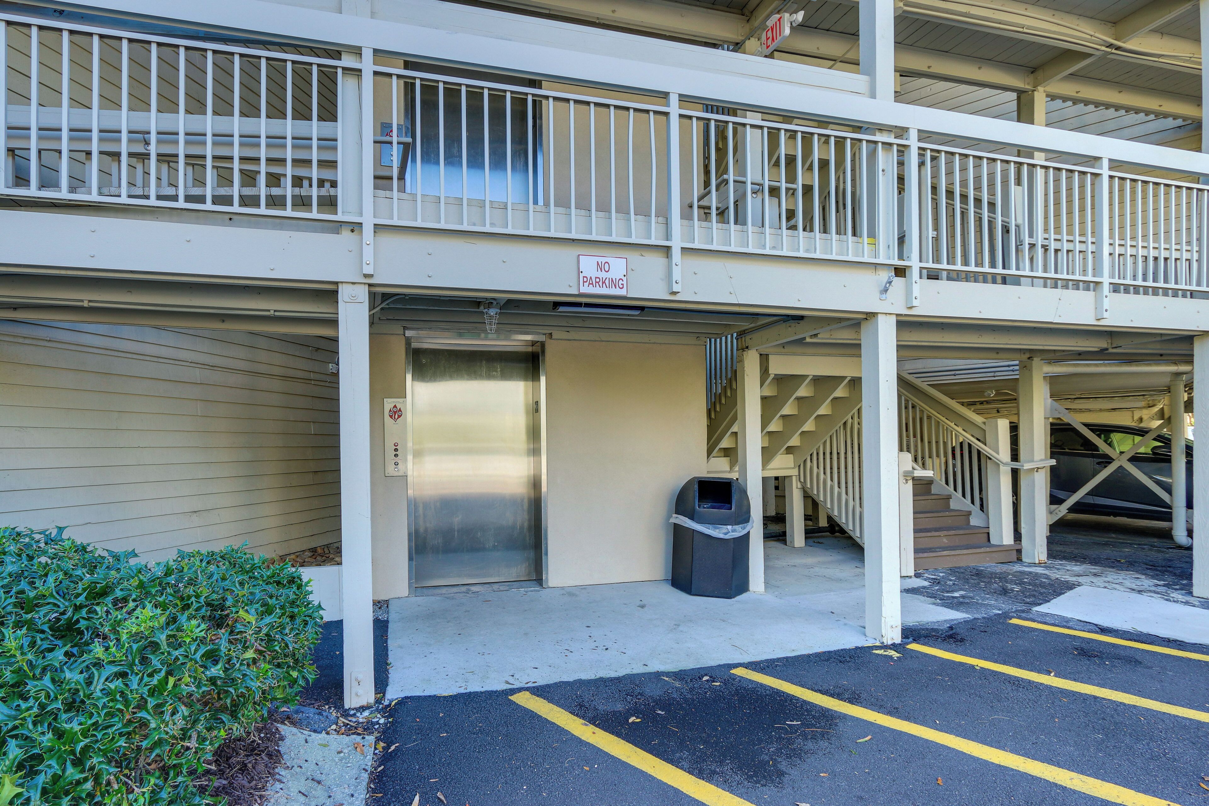 Un parking à plusieurs étages, avec un panneau indiquant «Interdiction de stationner», une poubelle et un escalier menant à un niveau supérieur.
