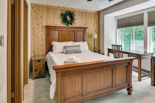 Un dormitorio con una cama de madera, una mesita de noche, un escritorio y una silla.
