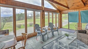 A spacious room with large windows, a wooden ceiling, and a view of a grassy landscape. - Tasteful Country Home on 5 Acres ~ 3 Mi to Lake! (Westmoreland)