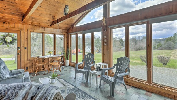 A wooden interior with large windows, a dining area, and seating. - Tasteful Country Home on 5 Acres ~ 3 Mi to Lake! (Westmoreland)