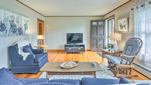 A living room with a sofa, a television, a wooden coffee table, and a rocking chair. - Tasteful Country Home on 5 Acres ~ 3 Mi to Lake! (Westmoreland)
