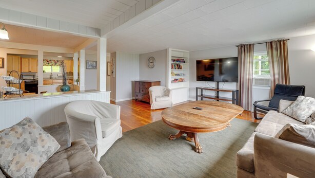A spacious living room with a wooden coffee table, white sofas, and a TV. - Beautiful Winter Escape on Bromley Mountain! (Peru)