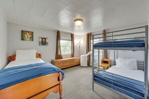 A room with a bunk bed, a wooden dresser, a desk, and two wall-mounted paintings. - Beautiful Winter Escape on Bromley Mountain! (Peru)