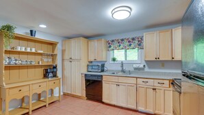 A kitchen with wooden cabinets, a dishwasher, a microwave, and a refrigerator. - Beautiful Winter Escape on Bromley Mountain! (Peru)