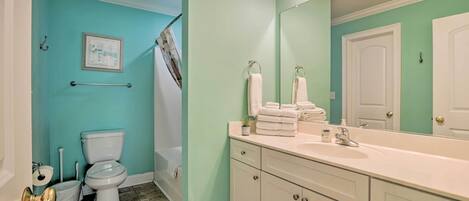 Une salle de bain avec des toilettes, un lavabo et un miroir.