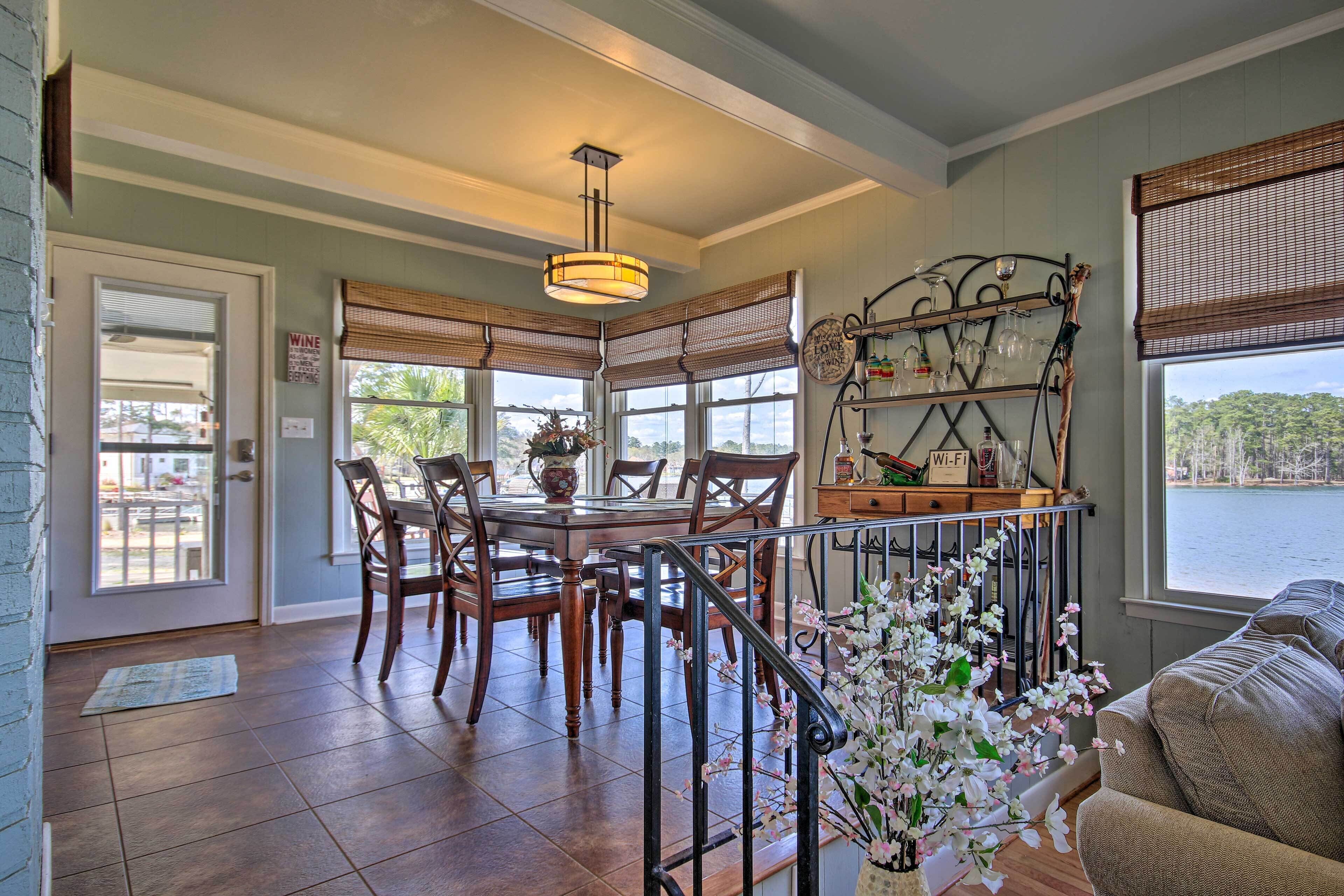 A dining area with a round table, chairs, and a hanging light fixture.