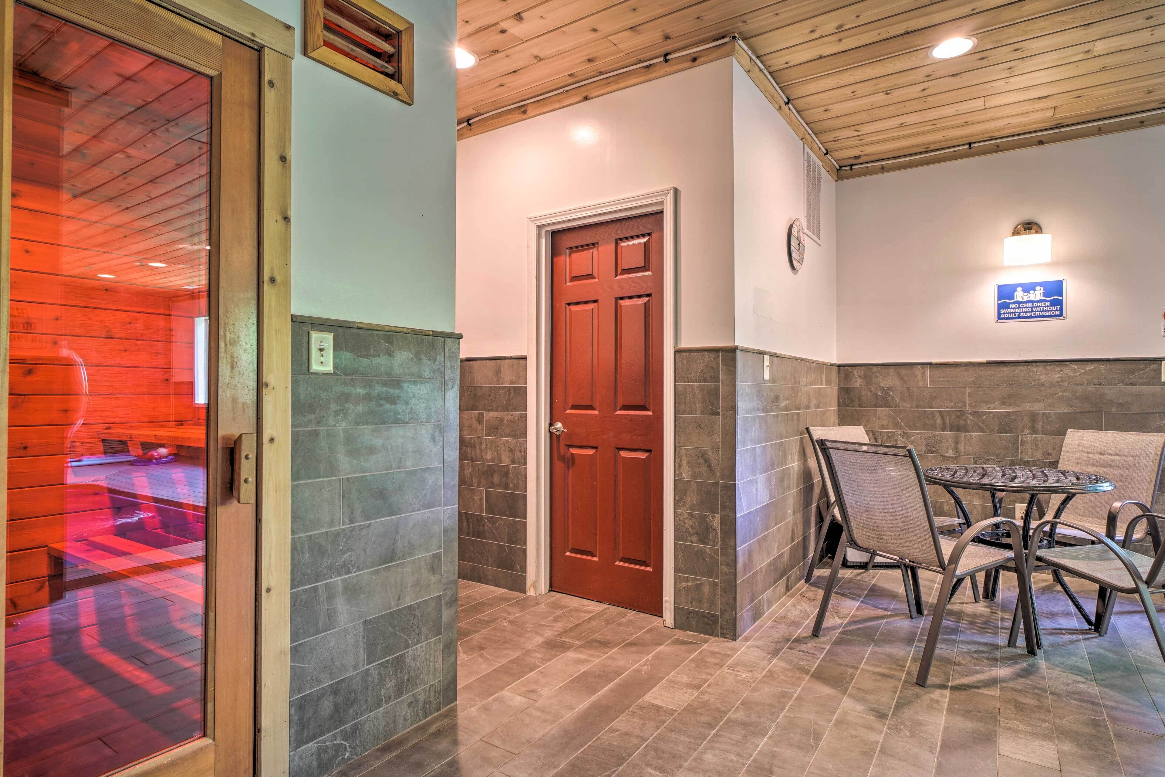 A wooden-paneled hallway with a red door, a stone-tiled floor, and a table with chairs.
