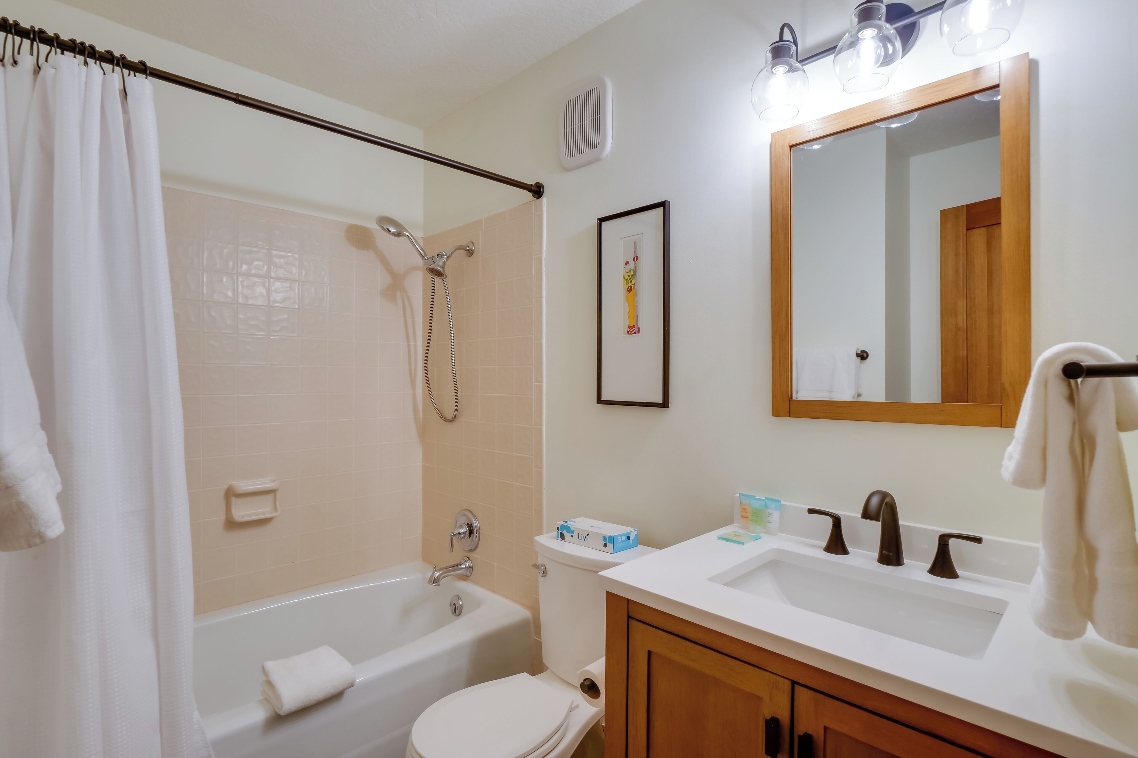 A bathroom with a bathtub, toilet, and sink.