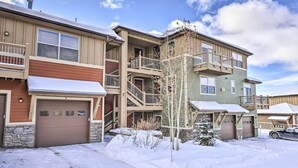 A multi-story residential building with a central staircase, multiple balconies, and a garage.