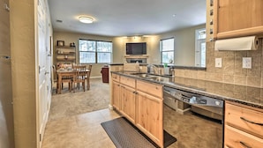 A modern kitchen with wooden cabinets, a built-in dishwasher, and a large island with a sink.