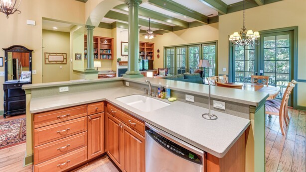 A spacious kitchen with a large island, built-in bookshelves, and a dining area with a view.
