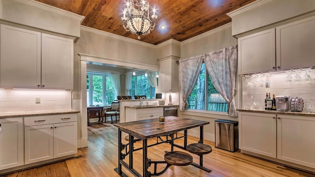 A spacious kitchen with wooden floors, white cabinetry, and a central island. - Spacious & Updated 1920's Hsnp Craftsmen Home (Hot Springs)
