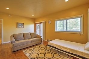 A bedroom with a bed, a sofa, a patterned rug, a window with blinds, and a door leading to another room. - Lake- & Mtn-view: Resort Hub in Silverthorne! (Silverthorne)