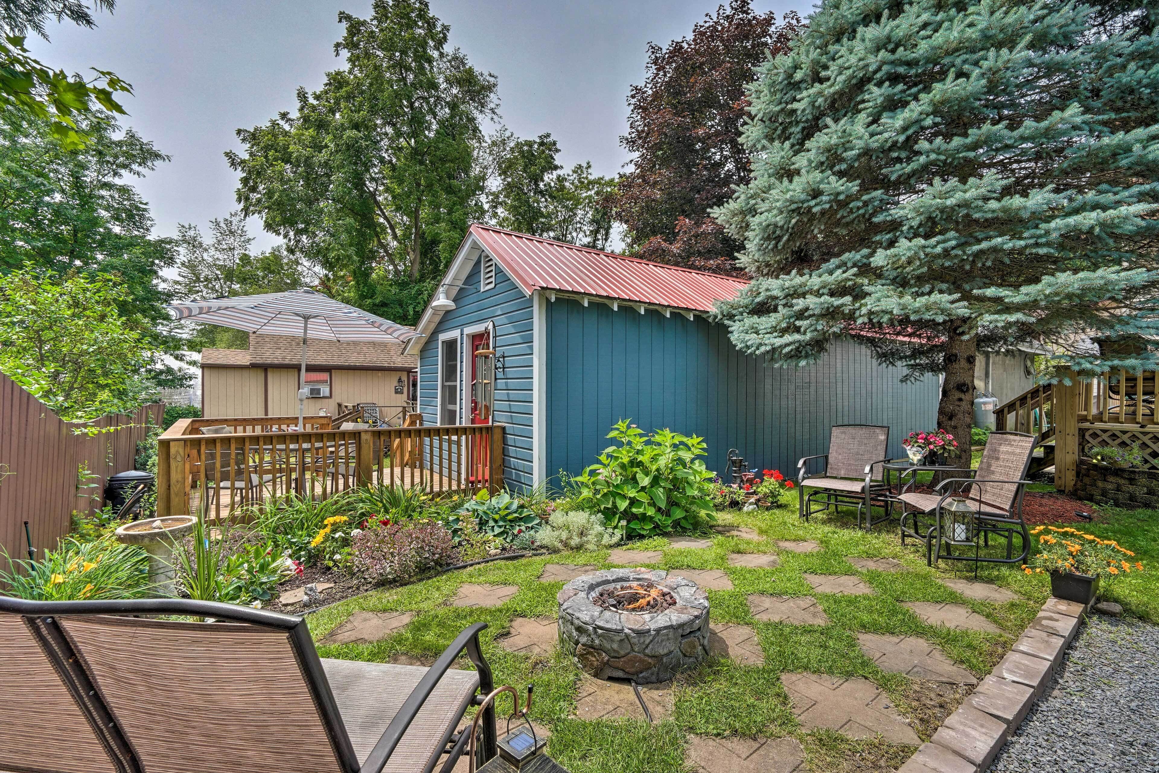 A backyard with a blue shed, a fire pit, and outdoor seating.