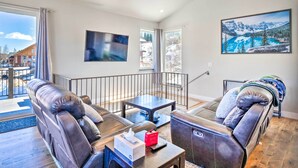 A modern living room with leather sofas, a coffee table, and a painting of a mountain landscape. - Alma Retreat w/ Mtn Views ~ 17 Mi to Breck! (Alma)