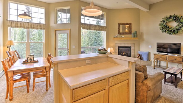 A spacious living room with a fireplace, a television, and a dining area with a table and chairs. - Silverthorne Gem w/ Community Perks: 11 Mi to Ski! (Silverthorne)