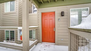 A snow-covered entrance with a red door, a metal gate, and a window with a view of the snowy landscape. - Silverthorne Gem w/ Community Perks: 11 Mi to Ski! (Silverthorne)